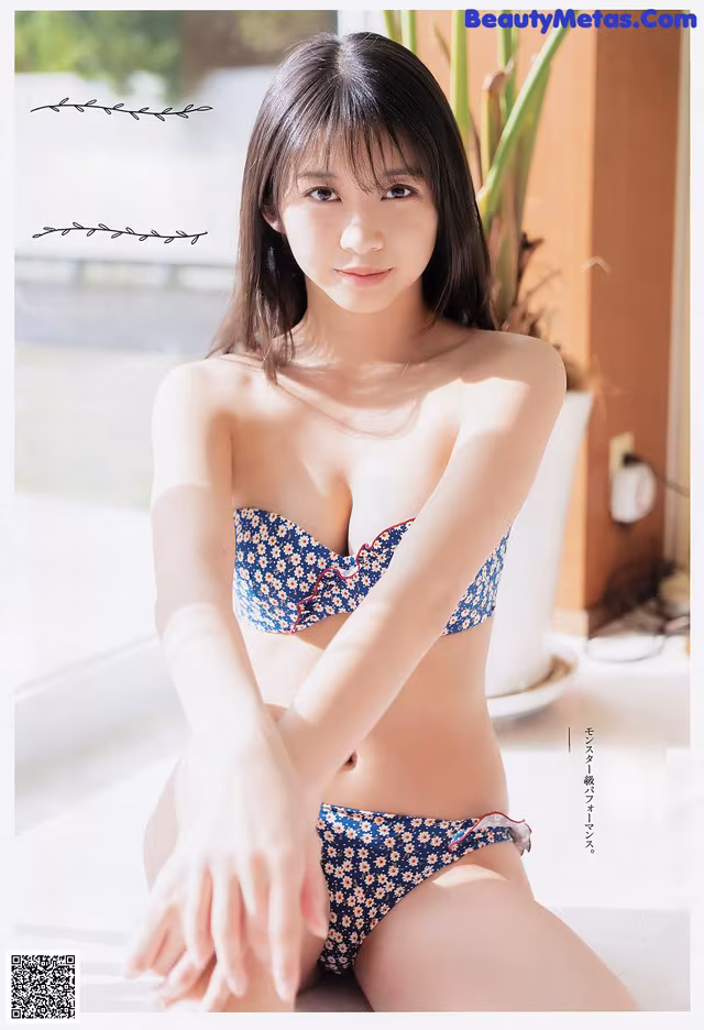 A woman in a blue and white bikini sitting on a table.