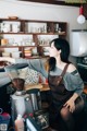 A woman in an apron preparing coffee in a coffee shop.