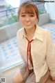 A woman in a white shirt and red tie posing for a picture.