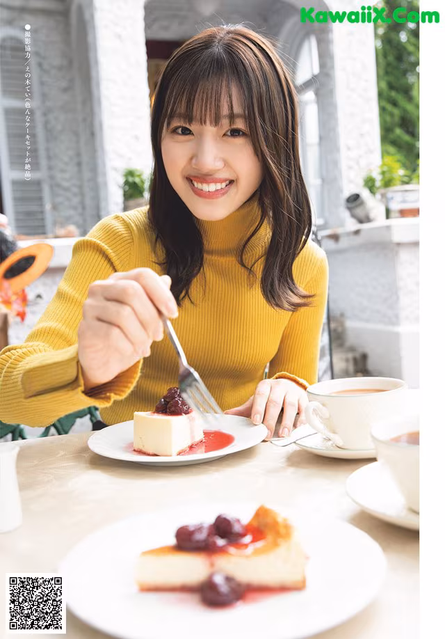 A woman sitting at a table with a plate of food.