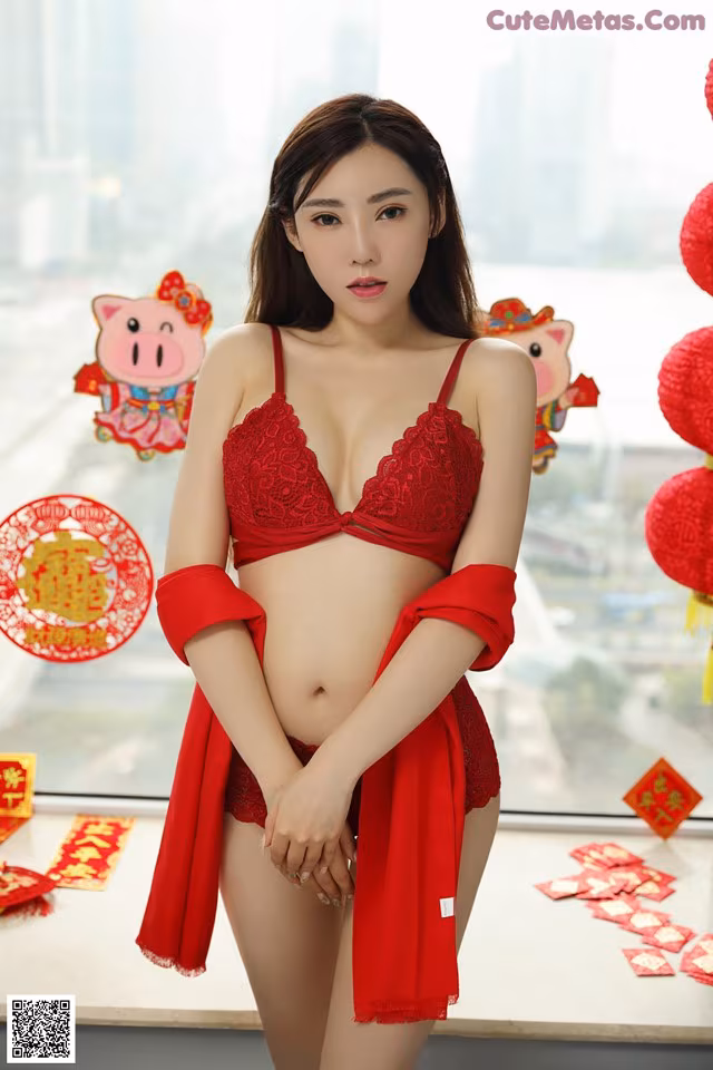 A woman in a red lingerie posing for a picture.