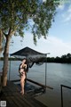 A woman standing on a dock next to a body of water.