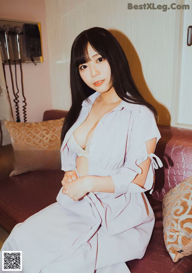A woman sitting on top of a couch in a room.