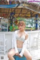 A woman sitting on a stool in front of a bar.