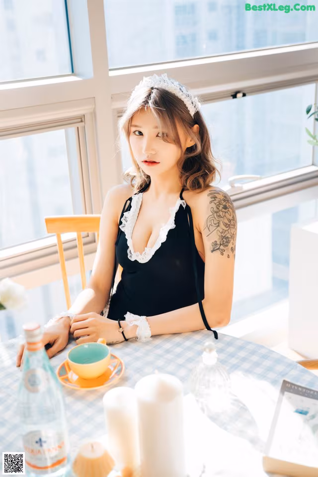 A woman sitting at a table with a cup of tea.
