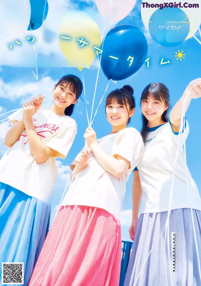 A group of young women holding balloons in front of a blue sky.