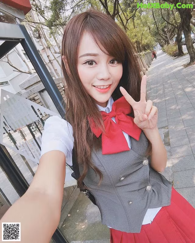 A woman in a school uniform posing for a picture.