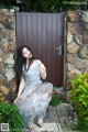 A woman sitting in front of a wooden door.