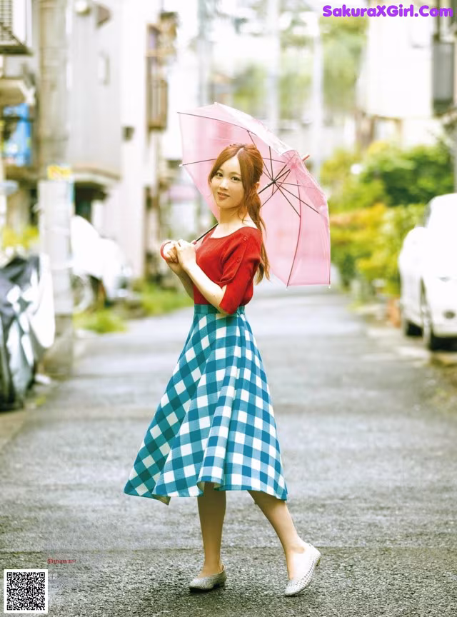 A woman walking down a street holding an umbrella.